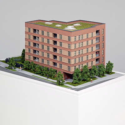 Beleuchtetes Architekturmodell einer Wohnanlage - Blick von oben auf Straßenseite