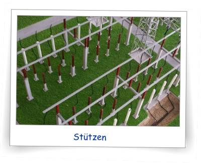 Bei diesem Modell zeigen sich sehr schön die Vorteile der Laserschneid-Technik. Speziell bei den Reihungen der Stützen. Die Stützen sind nämlich nicht einzelnd gestellt, sondern aus 1 Teil, das unter der Bodenplatte die Stützen miteinander verbindet. Dank dieser unterseitigen Verbindung stehen die Stützen alle senkrecht in beiden Achsen. Die Isolatoren sind konstruktiv und Laserschnnitt-technisch ebenfalls Teil der Stützen und sitzen somit ebenfalls kerzengerade. Pfiffige Lösung!